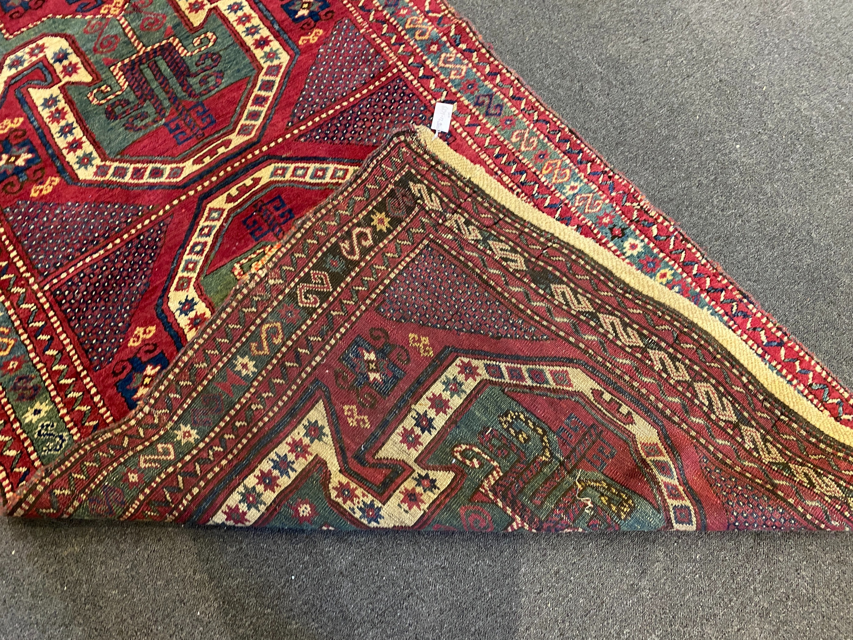 An antique Kazak red ground rug, 280 x 120cm